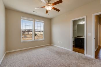 Carpeted Bedroom With Large Windows & Attached Bathroom